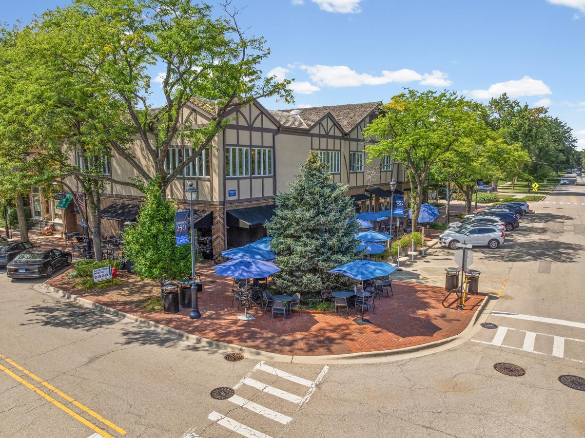 The Tudor building on the Glencoe plaza, with outdoor seating under blue umbrellas