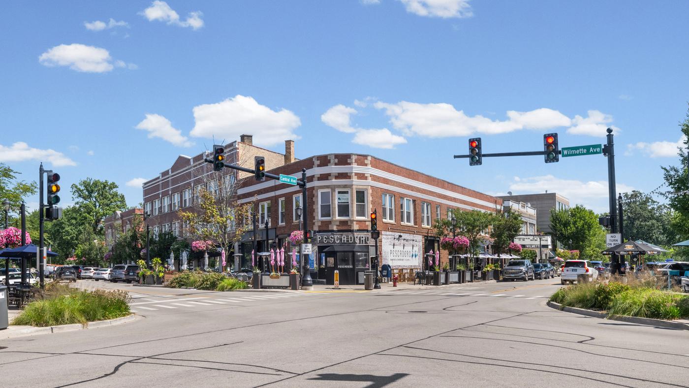 The corner of Central Avenue and Wilmette Avenue in downtown Wilmette, with storefronts and sidewalk seating