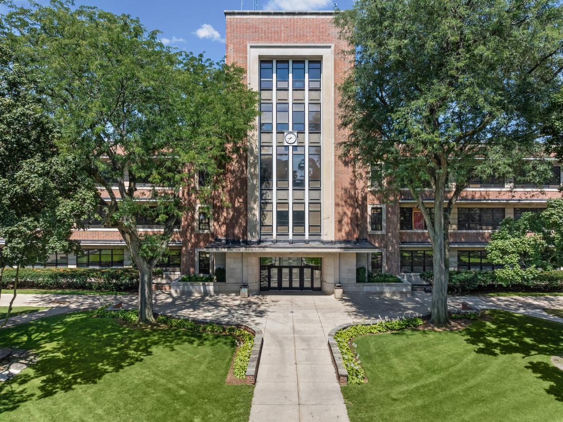 The brick and limestone facade of New Trier High School's Winnetka campus, seen across the front lawn